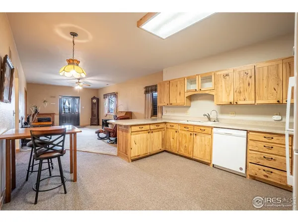 a kitchen with granite countertop a stove a sink a dining table and chairs