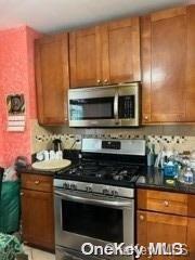 164-54 Nadal Place Queens, NY 11433 - Photo 3 of 9 a kitchen with granite countertop a stove top oven microwave and cabinets