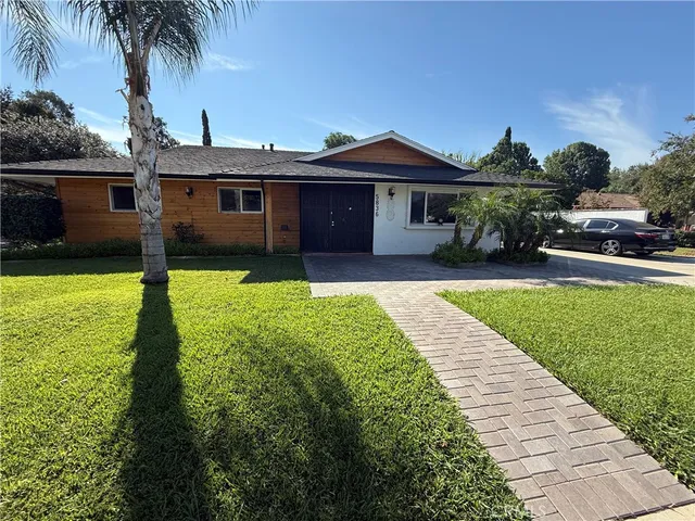 a front view of a house with a garden and yard