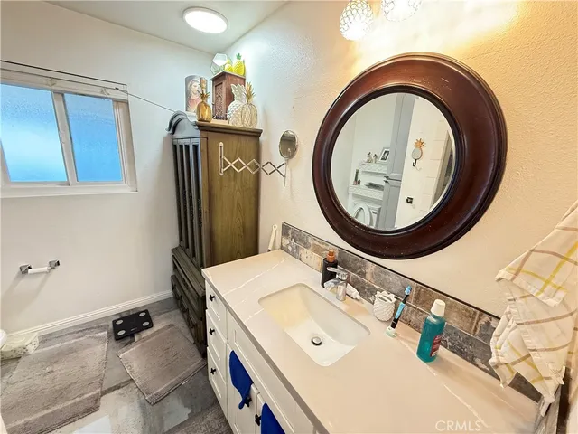 a bathroom with a granite countertop sink a mirror and shower