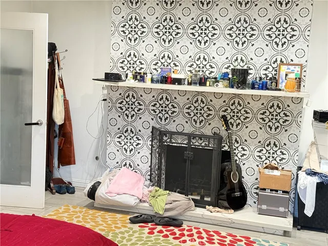 a living room with stainless steel appliances furniture a rug and a kitchen view