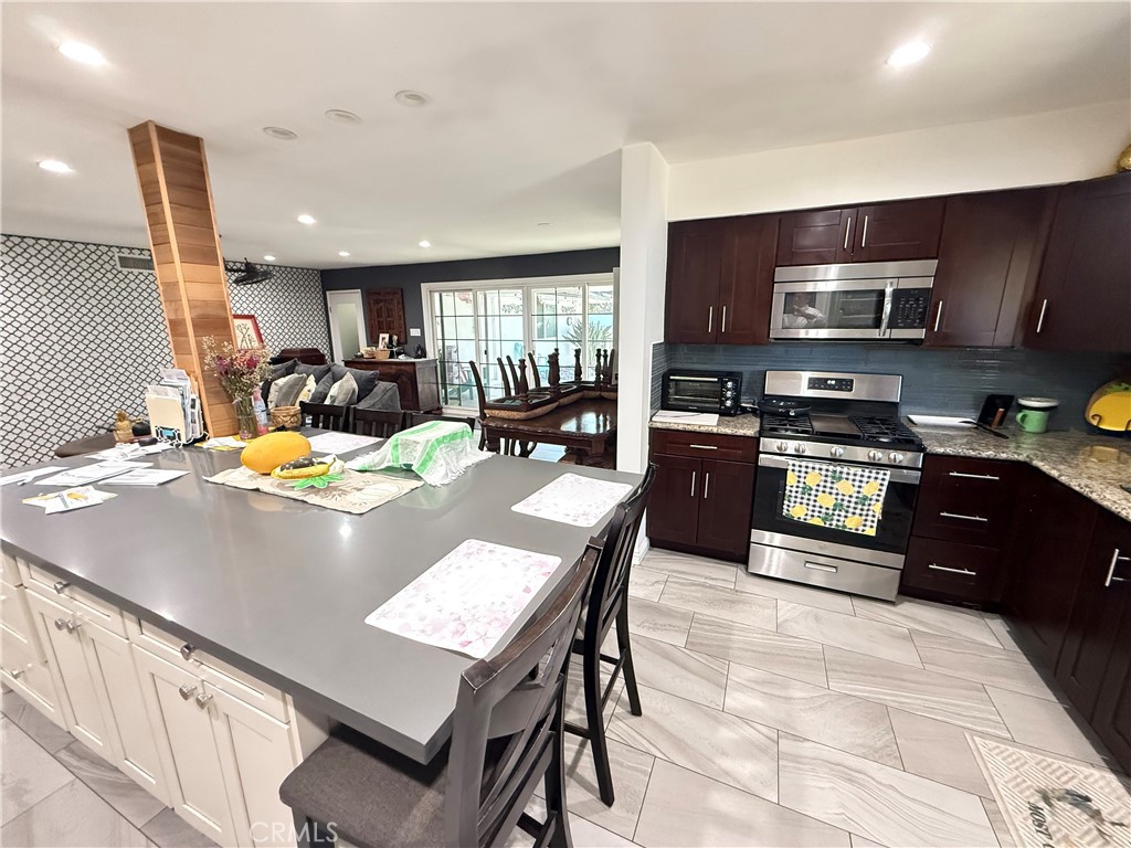 5836 Old Ranch Road Riverside, CA 92504 - Photo 43 of 59 a view of a kitchen with kitchen island a stove a sink a refrigerator and a dining table