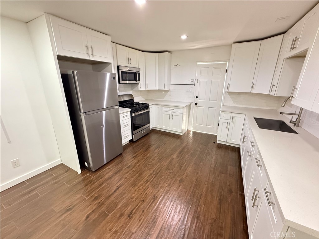 5836 Old Ranch Road Riverside, CA 92504 - Photo 52 of 59 a kitchen with a refrigerator a sink and dishwasher with wooden floor