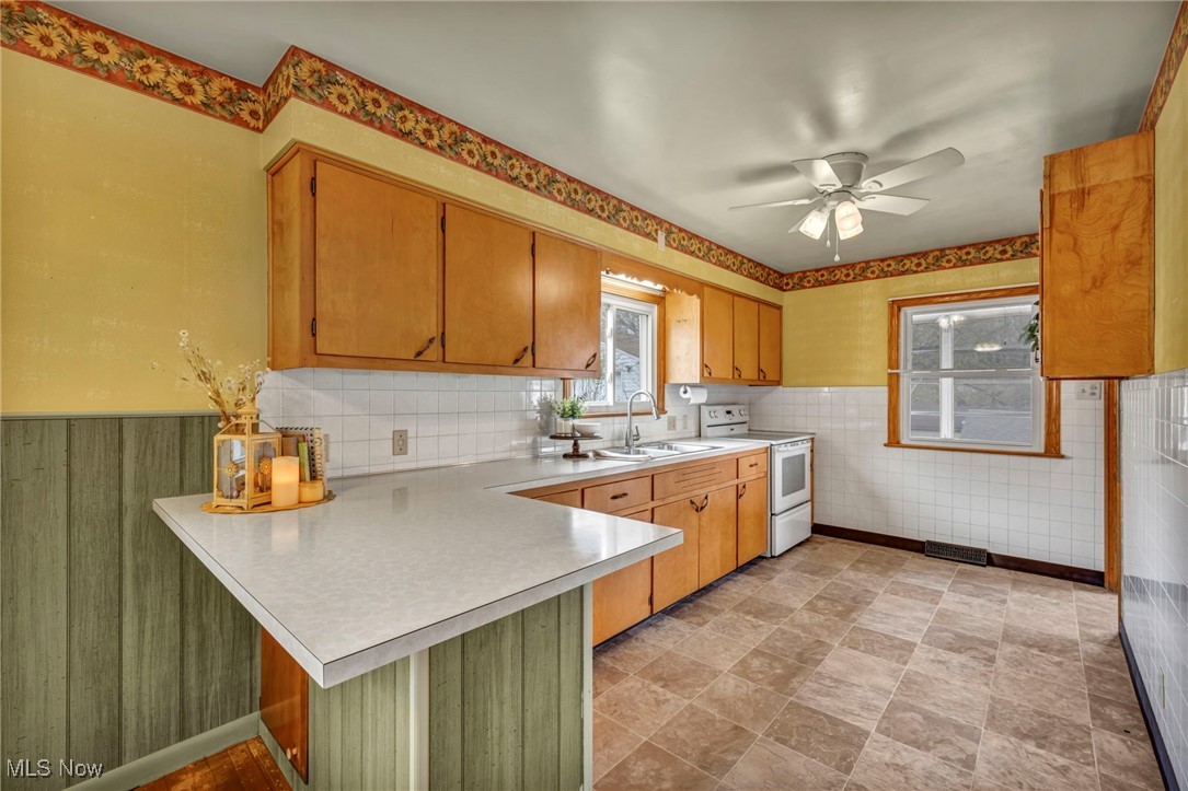 367 High Grove Boulevard Akron, OH 44312 - Photo 14 of 46 Kitchen with white electric range, a sink, ceiling fan, light countertops, and a peninsula