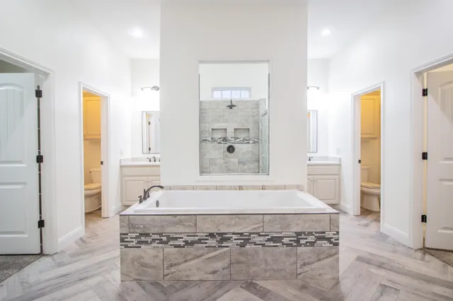 a bathroom with a granite countertop sink mirror and a shower