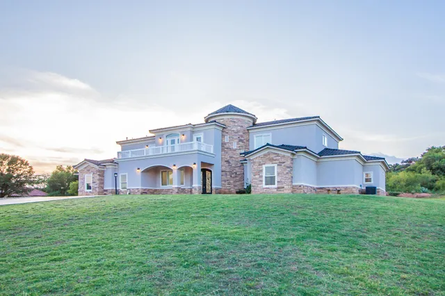 a large white house with a big yard and large trees
