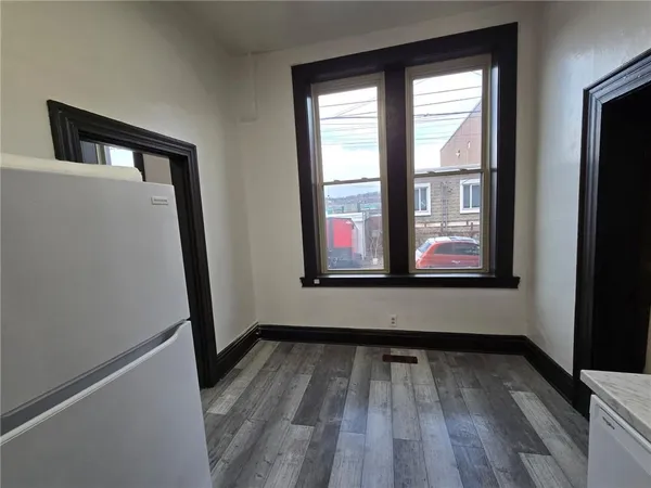 a view of empty room with wooden floor