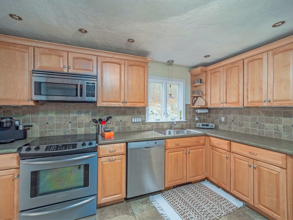 59 Rattlesnake Hill Road Andover, MA 01810 - Photo 13 of 39 a kitchen with stainless steel appliances granite countertop a stove sink microwave and cabinets