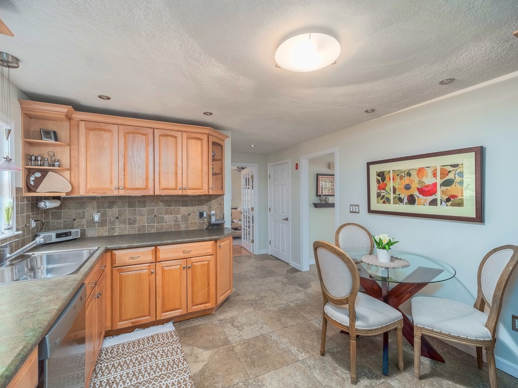 59 Rattlesnake Hill Road Andover, MA 01810 - Photo 10 of 39 a kitchen with stainless steel appliances granite countertop a sink a stove a dining table and chairs
