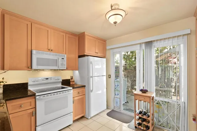 a kitchen with a refrigerator a stove top oven cabinetry and a sink