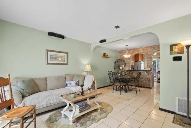 a living room with furniture and a dining table with chair