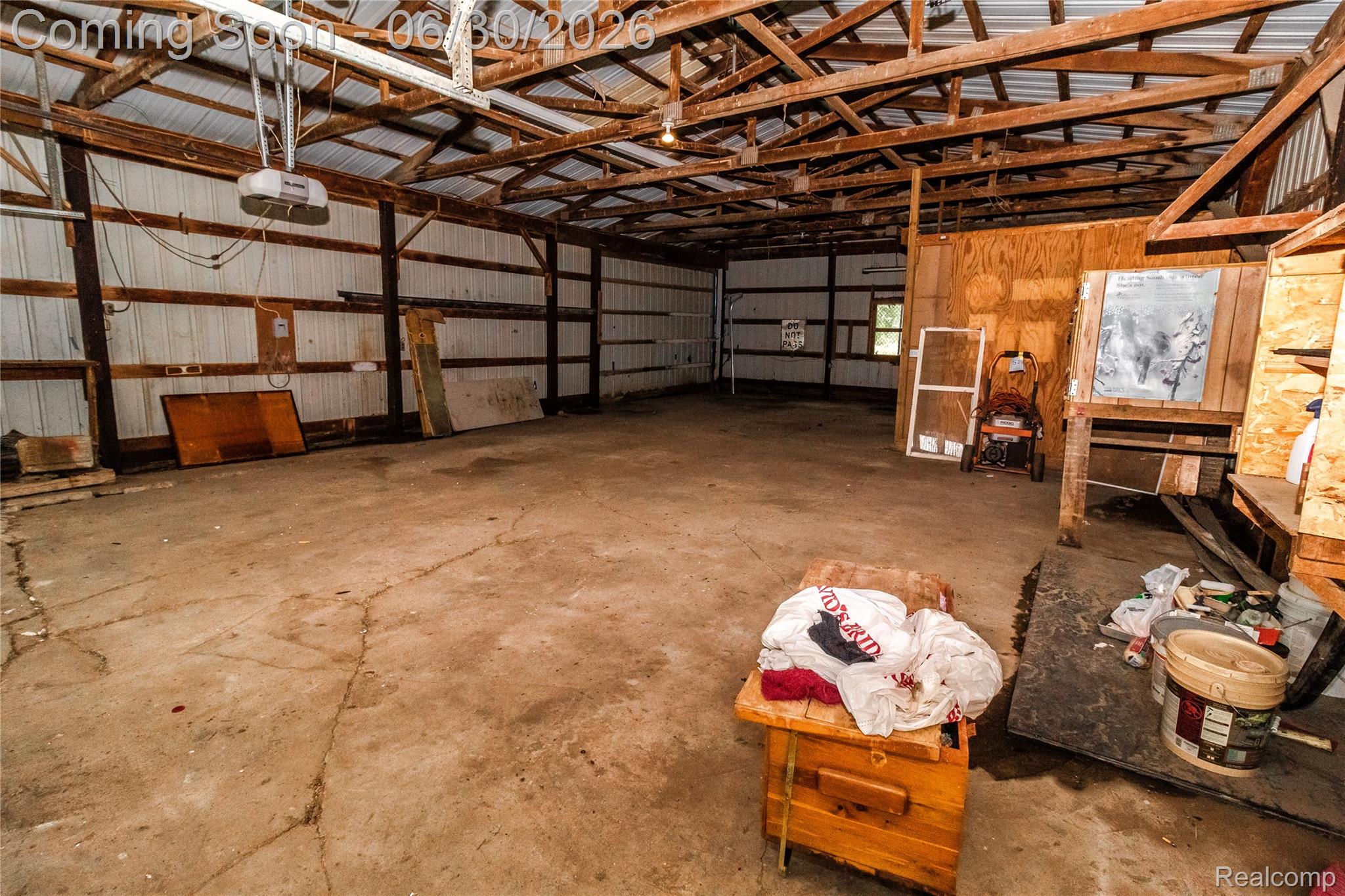 8150 Norman Road Imlay City, MI 48444 - Photo 54 of 58 Spacious interior featuring exposed wood beam ceiling, corrugated metal walls, concrete flooring, and built-in shelving