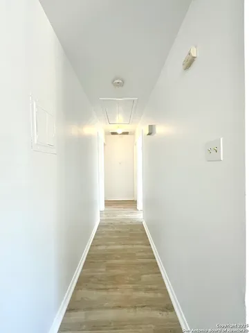 a view of a hallway with wooden floor