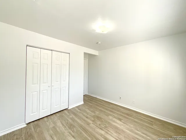 an empty room with wooden floor and sliding door