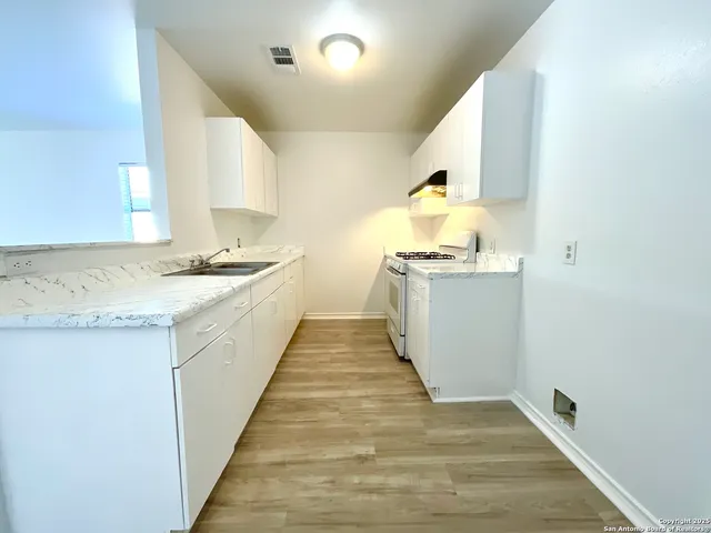 a kitchen with granite countertop a sink and a stove