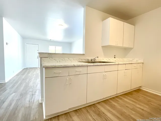 a kitchen with granite countertop white cabinets and white appliances