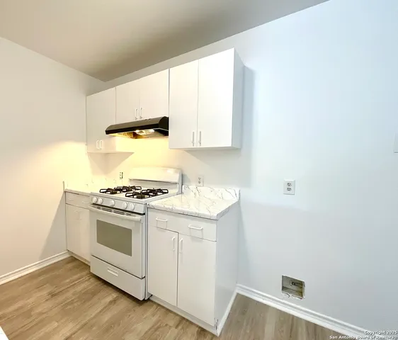 a kitchen with a stove and a white cabinet