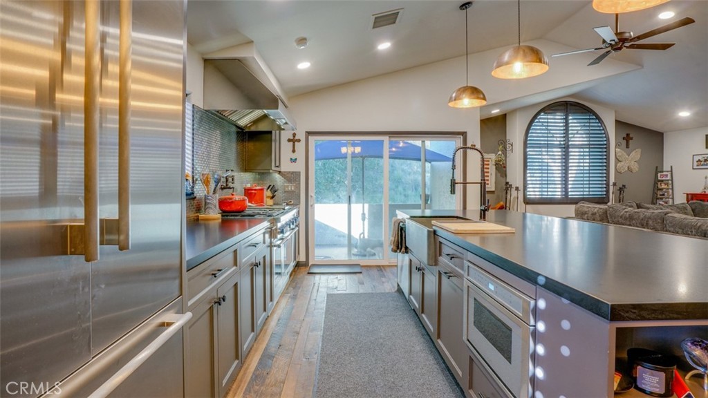 11327 Old Ranch Circle Chatsworth, CA 91311 - Photo 25 of 63 a kitchen with stainless steel appliances granite countertop a sink a stove and a wooden floors