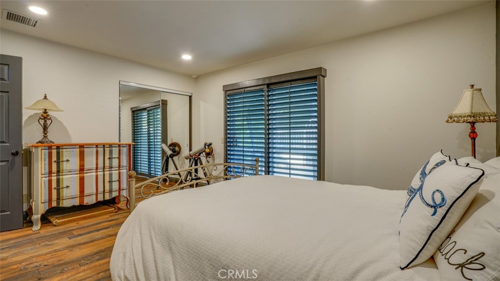 11327 Old Ranch Circle Chatsworth, CA 91311 - Photo 40 of 63 a bedroom with a bed and dresser with wooden floor