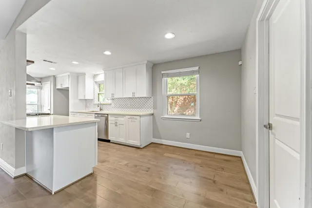 a kitchen with a sink window and cabinets