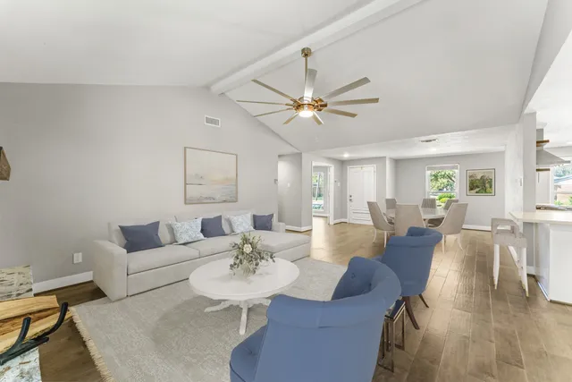 a living room with furniture a chandelier and a dining table