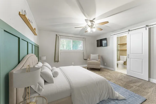 a bedroom with a bed couch and a window