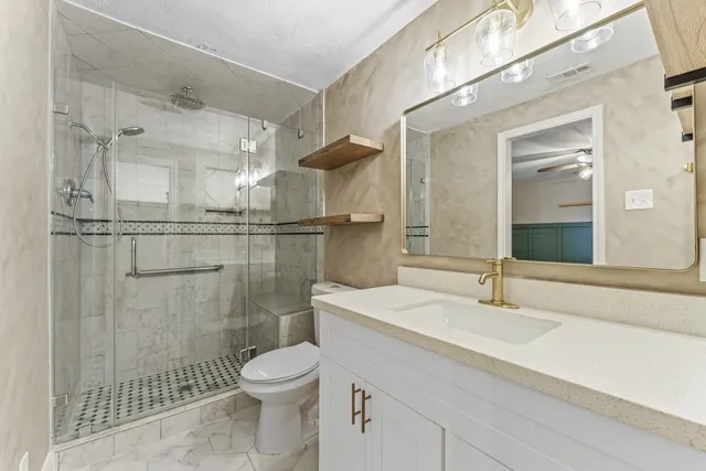 a bathroom with a sink toilet a mirror and shower