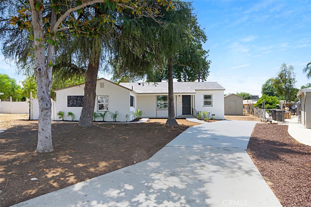 a view of a house with a yard and large tree