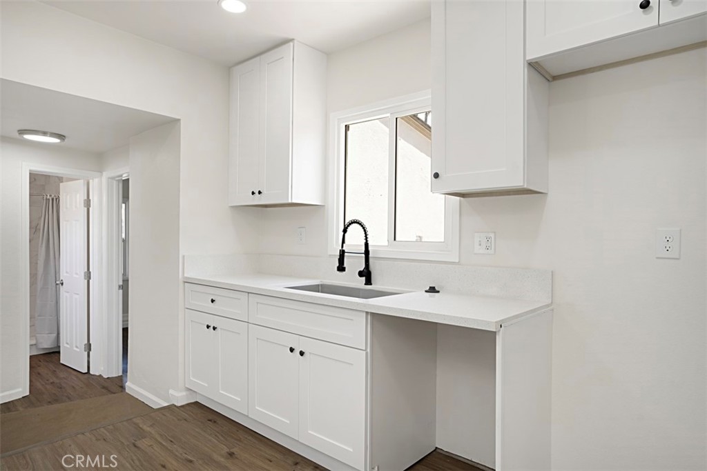 6056 Colonial Drive Riverside, CA 92506 - Photo 13 of 30 a kitchen with white cabinets a sink and dishwasher