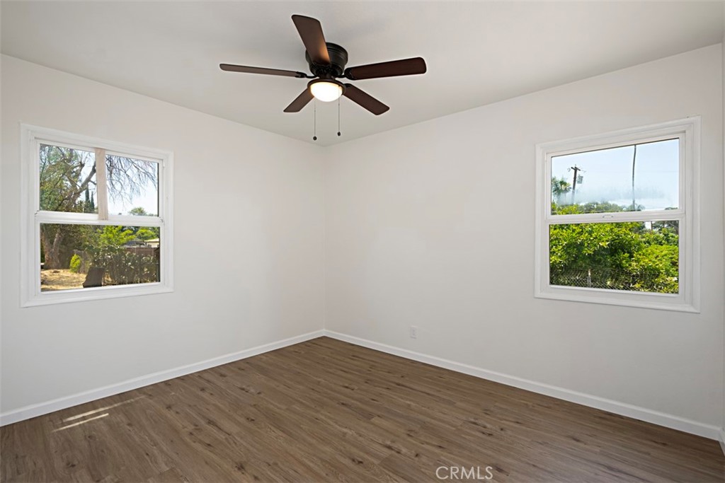 6056 Colonial Drive Riverside, CA 92506 - Photo 24 of 30 a view of a big room with wooden floor a ceiling fan and windows
