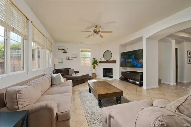 a living room with furniture a fireplace and a large window