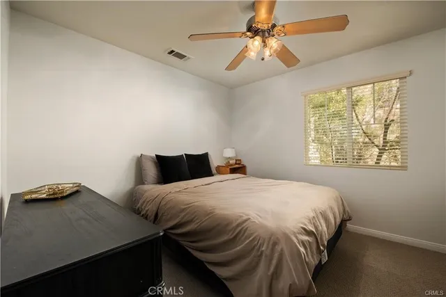 a bedroom with a bed and a ceiling fan