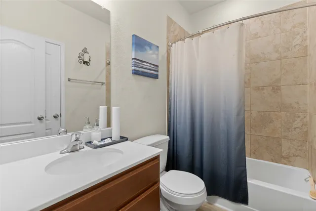 a bathroom with a sink a toilet a mirror and shower