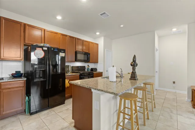 a kitchen with stainless steel appliances granite countertop a refrigerator and microwave