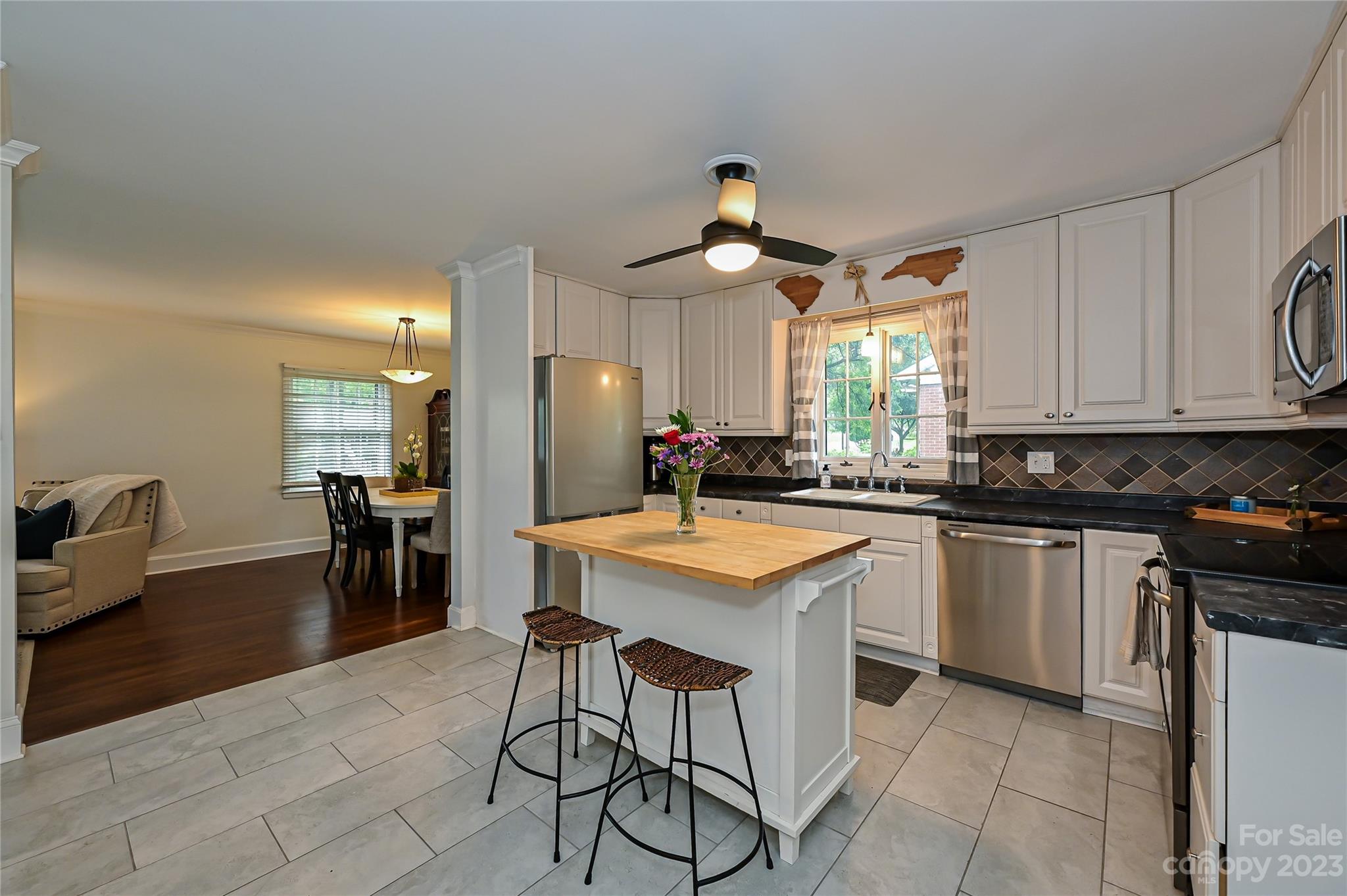 5511 Valley Forge Road Charlotte, NC 28210 - Photo 6 of 22 a kitchen with stainless steel appliances kitchen island granite countertop a sink a stove a dining table and chairs