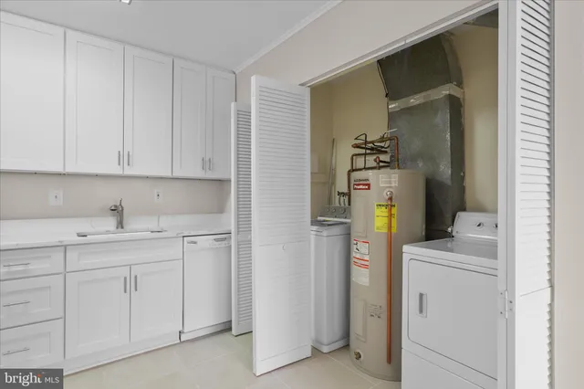 a utility room with cabinets washer and dryer