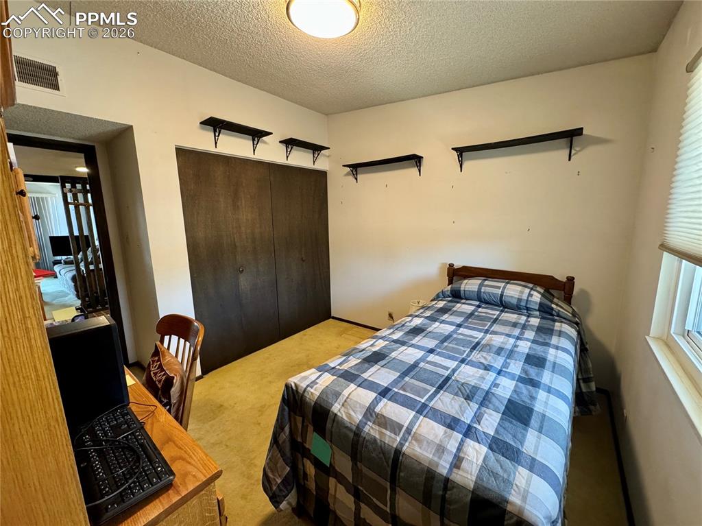 1034 Fontmore Road, Unit D Colorado Springs, CO 80904 - Photo 14 of 23 a bedroom with a bed and a walk in closet