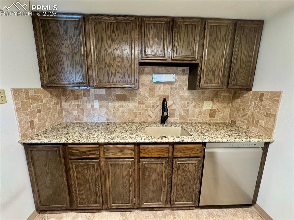 1034 Fontmore Road, Unit D Colorado Springs, CO 80904 - Photo 5 of 23 a kitchen with granite countertop a sink and a wooden cabinets