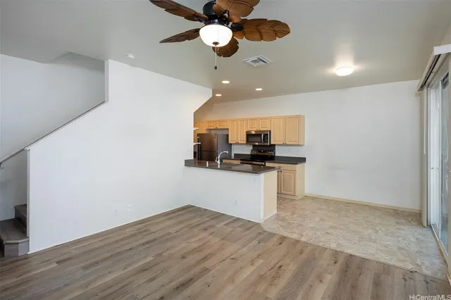 a kitchen with a refrigerator and ceiling fan
