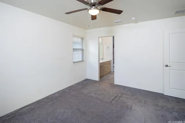 an empty room with closet and a chandelier fan