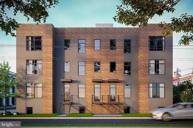 a front view of a residential apartment building with a yard