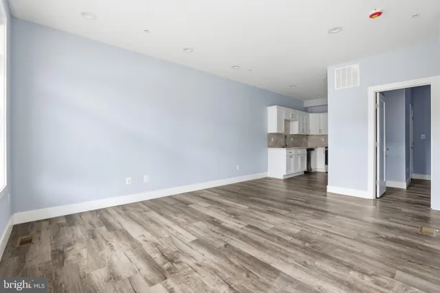 a view of empty room with wooden floor