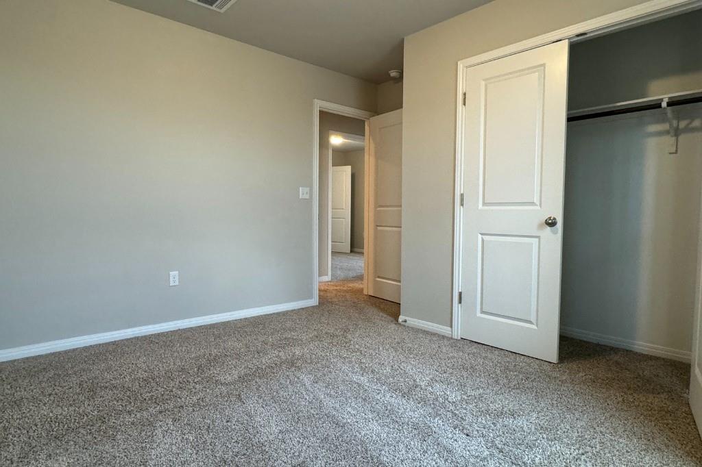 12604 Dairywork Road Buda, TX 78610 - Photo 15 of 20 A well-lit bedroom features plush carpeting and convenient closet access.