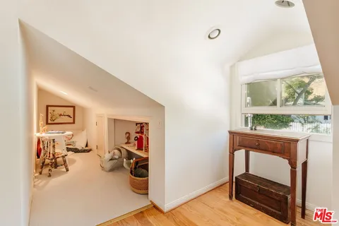 a spacious bedroom with a bed and wooden floor