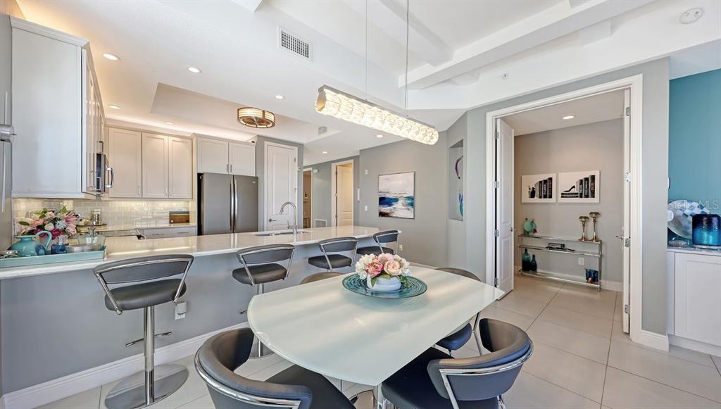 10530 Boardwalk Loop, Unit 505 Lakewood Ranch, FL 34202 - Photo 16 of 67 a kitchen with a dining table and chairs