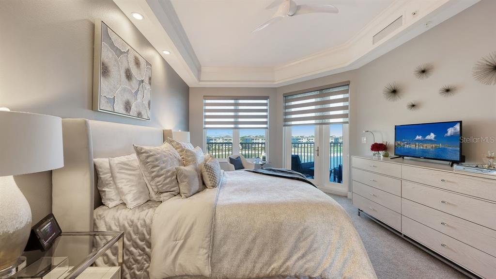 10530 Boardwalk Loop, Unit 505 Lakewood Ranch, FL 34202 - Photo 21 of 67 a bedroom with a large bed and a flat screen tv