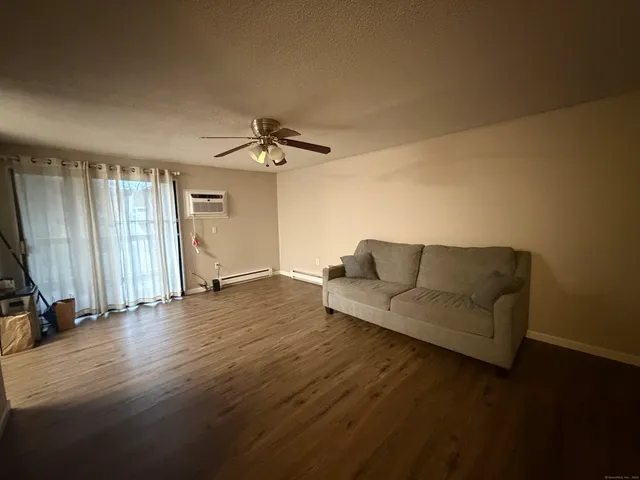a living room with furniture and a ceiling fan
