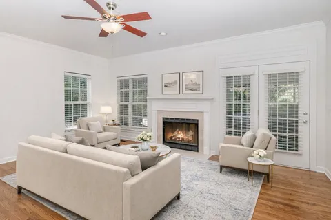 a view of an empty room with wooden floor fireplace and a window