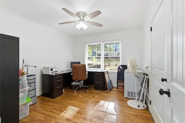 a view of a workspace with furniture and a window