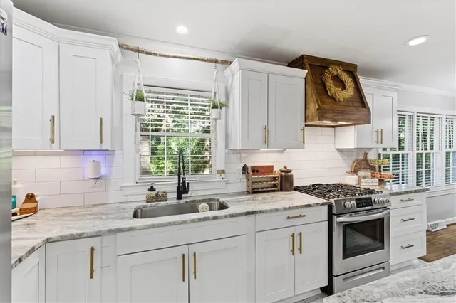 a kitchen with granite countertop kitchen island and stainless steel appliances